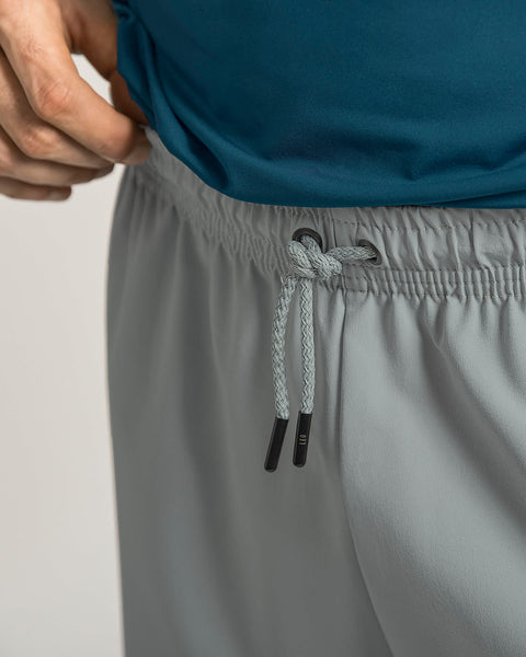 Pantaloneta deportiva con acabado antifluidos y bolsillos funcionales#color_750-gris-claro